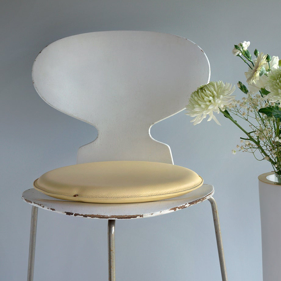 Round leather seat (seat cushion) in Pale Pineapple with Misty Green stitching on chair