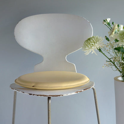 Round leather seat (seat cushion) in Pale Pineapple with Misty Green stitching on chair